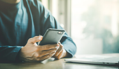 Man holding and using smartphone for sms messages, hipster man typing touchscreen cell phone in the cafe. business, lifestyle, technology and Social media network concept.