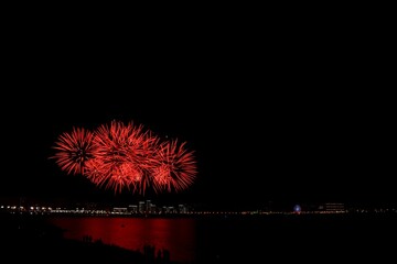 Fireworks in the night sky over the river.