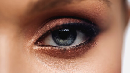 Obraz premium close up view of young woman with grey eye and makeup looking at camera.
