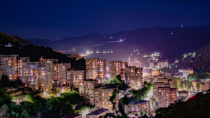 Night city from a bird's eye view. The light of houses and cars. A beautiful city with rivers, bridges and beautiful buildings. City among the mountains, Kapan, Armenia