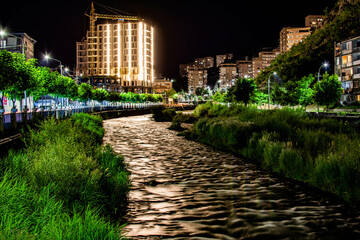 Night city from a bird's eye view. The light of houses and cars. A beautiful city with rivers, bridges and beautiful buildings. City among the mountains, Kapan, Armenia