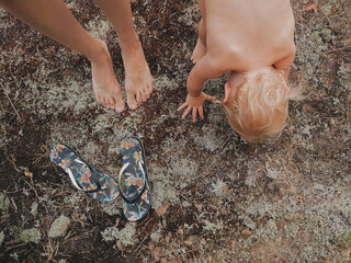 Sensory Development in Children. 12 months old baby boy standing on moss and touching it. Toddler and nature. Baby yoga. Exercises