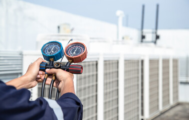 Technician is checking air conditioner ,measuring equipment for filling air conditioners , service and maintenance air conditioner .