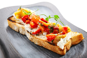 Delicious bruschetta with baked peppers close up view