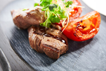 Grilled marbled beef with tomatoes closeup view