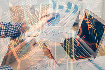 Technology theme hologram with man working on computer on background. High tech concept. Multi exposure.