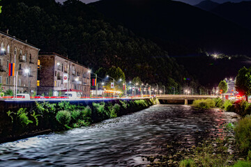 Obraz premium Night city from a bird's eye view. The light of houses and cars. A beautiful city with rivers, bridges and beautiful buildings. City among the mountains, Kapan, Armenia