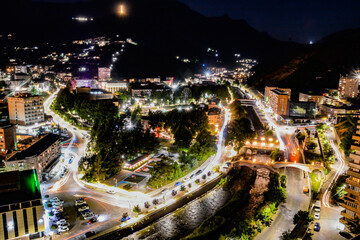 Fototapeta premium Night city from a bird's eye view. The light of houses and cars. A beautiful city with rivers, bridges and beautiful buildings. City among the mountains, Kapan, Armenia