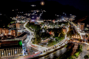 Fototapeta na wymiar Night city from a bird's eye view. The light of houses and cars. A beautiful city with rivers, bridges and beautiful buildings. City among the mountains, Kapan, Armenia