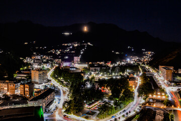 Fototapeta premium Night city from a bird's eye view. The light of houses and cars. A beautiful city with rivers, bridges and beautiful buildings. City among the mountains, Kapan, Armenia