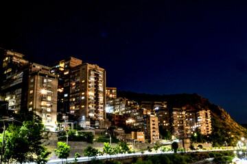 Obraz premium Night city from a bird's eye view. The light of houses and cars. A beautiful city with rivers, bridges and beautiful buildings. City among the mountains, Kapan, Armenia