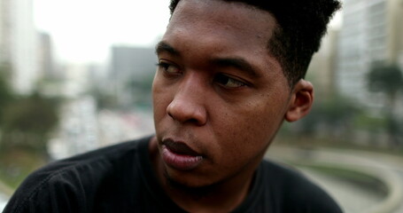 Frustrated young black African man standing outside in city