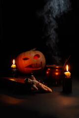 Naklejka premium Halloween pumpkin with burning mouths, book and a voodoo doll - volt on dark background.