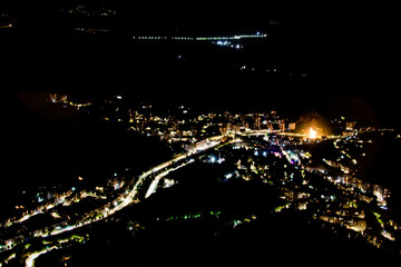 Night city from a bird's eye view. The light of houses and cars. A beautiful city with rivers, bridges and beautiful buildings. City among the mountains, Kapan, Armenia