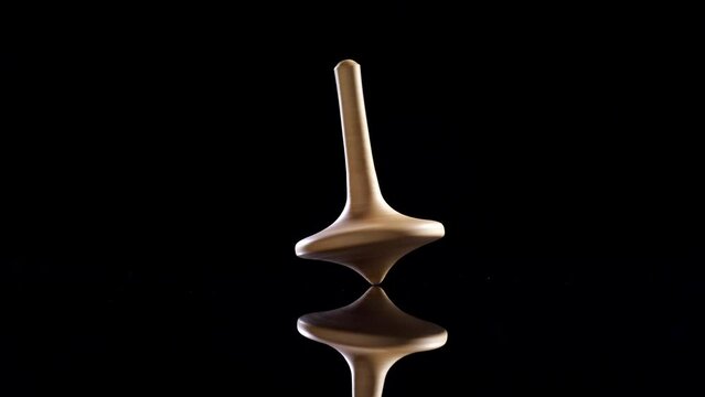 Close up shot of a wooden spinning top moving.