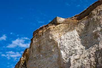 Blockhaus en surplomb sur une falaise de Seine-maritime sur le point de s'effonder sur la plage
