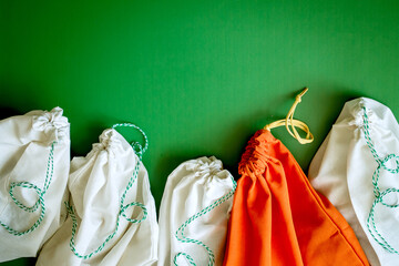 zero waste products in reusable cotton bags on a green background