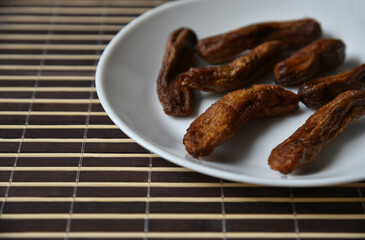 Dried sweet bananas white on white background. Green natural background. White isolated background. Vegetarian food.