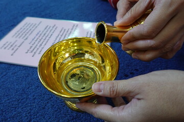 Pouring water ritual after making merit in Buddhism, symbolizing dedication of merit, mindfulness, and Thai religious tradition.