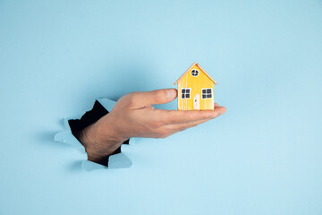 Real estate concept. Man holding house model