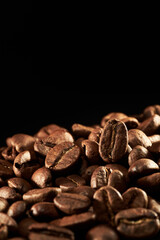 Roasted coffee beans isolated close up on black background, clipping path