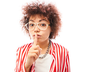 Young positive kazakh girl with afro hairstyle put finger on lips shh keep silence and secret isolated on white background - obrazy, fototapety, plakaty