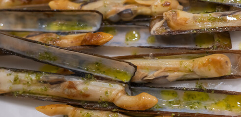 Deliciosa ración de navajas a la plancha con aceite de oliva virgen extra y perejil en un restaurante