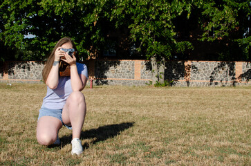 Young woman taking picture with an old/vintage film camera	
