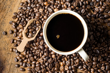 Black coffee in a white ceramic mug. on the ground coffee beans. soft focus.shallow focus effect.