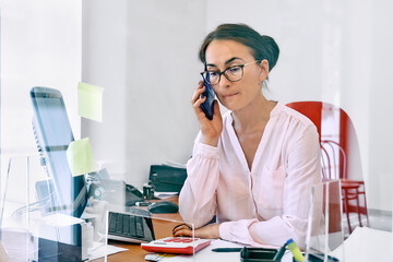 Middle-aged woman social worker check accounts bills, using smartphone to communicate or chat with...