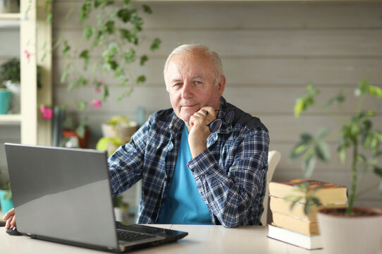 Elderly Man Working On Computer While Sitting At Home