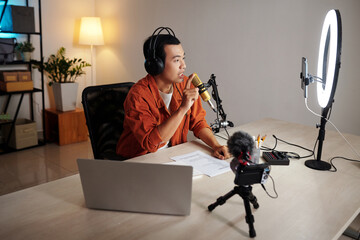 Serious blogger recording podcast on emotional topic in his home studio and sharing his opinion...
