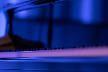 A black piano in dim stage lights just before a performance Nr.1