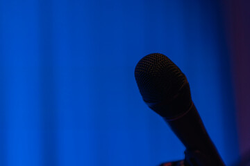 A black microphone on a blue background on stage before a performance Nr.2