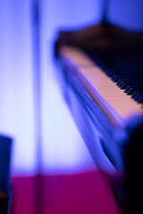 A black piano in dim stage lights just before a performance Nr.4