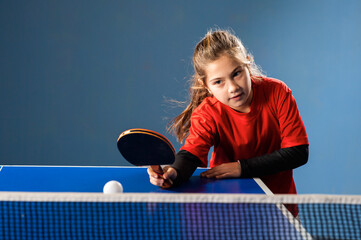 girl child plays ping pong on indoor - obrazy, fototapety, plakaty