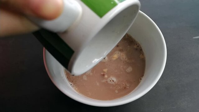 Making Milo Nutri Breakfast. Pour hot water into the dry ingredients.