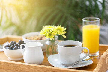 Wooden tray with breakfast on the bed