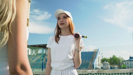 Fototapeta na wymiar 4K. Girls tennis players communicate on the tennis court.
