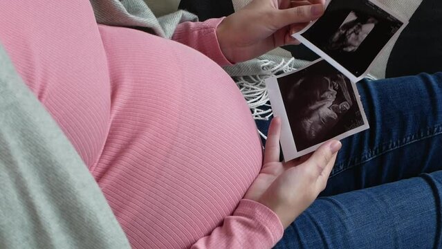 A woman expecting the birth of her baby looks at a picture. Pregnancy and childbirth.