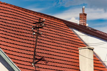 Red tiled roof with an old power or electrical wooden pole on it