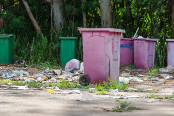 Several plastic bins are left in the garbage collection area, causing pollution.