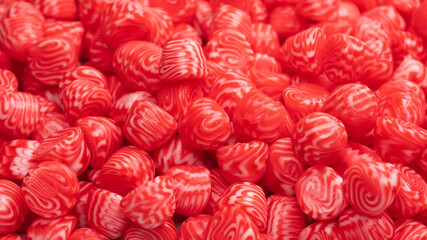 Red round tasty gummy candies as a background.