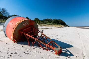 Old red and black signaling beacon stranded on the beach, Kiyu, San José, Uruguay.