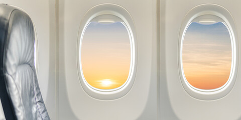 Windows and seat inside airplane flying on sunset sky in the morning