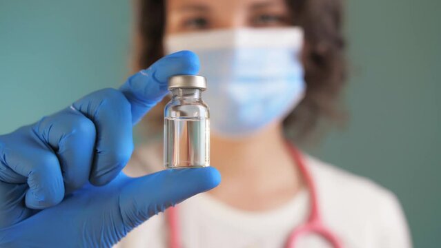 Woman Doctor holds an ampule with medicine in her hand. vaccine for disease in doctor hand. covid 19. the doctor prescribed an injection treatment. doctor is ready to give an injection to patient