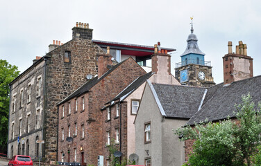 Fototapeta premium View of Old Stone Building with Modern Extension with Distant Clock Tower 