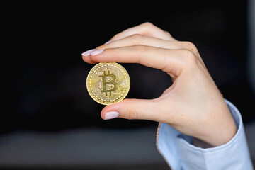 Plakat Woman holding a physical bitcoin cryptocurrency in her hand