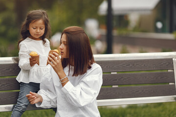 Mother with daughter eats ice cream in the city