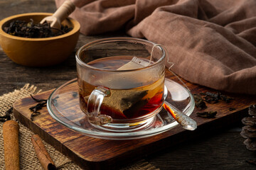 Black tea,Tea bag in hot water in glass cup on wooden table